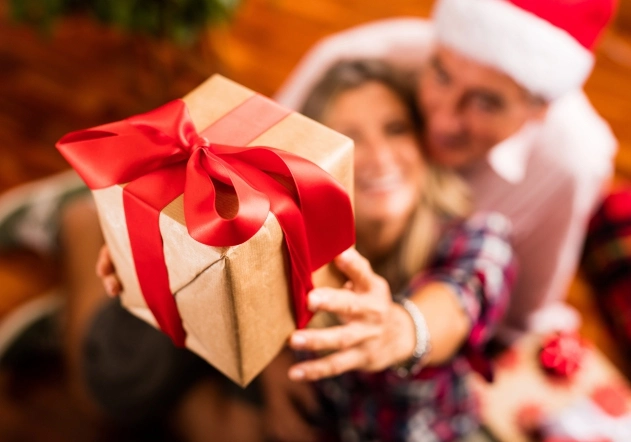 Pareja sosteniendo regalo de navidad