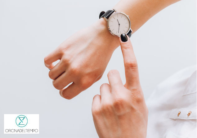 Mujer señalando su reloj de pulsera 